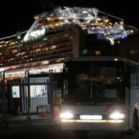 A bus transports British passengers from the coronavirus-hit cruise ship Diamond Princess at the Daikoku Pier Cruise Terminal in Yokohama on Friday. | REUTERS