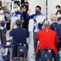 Volunteers see off Paralympic athletes who are returning home via Tokyo\'s Haneda airport on Monday. | KYODO