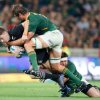 All Blacks flyhalf Beauden Barrett (left) is tackled by South Africa prop Frans Malherbe (right) and Eben Etzebeth during their Rugby Championship match in Mbombela, South Africa, on Saturday. | AFP-JIJI