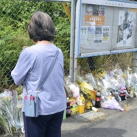 A woman prays for victims in a shooting incident at the Ground Self-Defense Force\'s shooting range in the city of Gifu last month. | KYODO