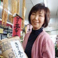 Top grade: The manager of a Sapporo rice shop holds a bag of Yumepirika rice, produced in Hokkaido, on Monday. | KYODO