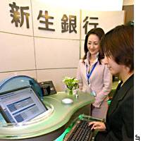 A customer tries to conduct a mobile banking transaction on the Internet Tuesday at Shinsei Bank\'s new mini-outlet in Tokyo\'s Ginza district. | HIROKO NAKATA PHOTO