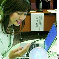 A woman demonstrates a \"scent-generator\" developed by NTT Communications Corp. that enables users to smell fragrances sent over the Internet. | KAHO SHIMIZU PHOTO