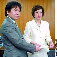 Fusae Ota hands a petition on Osaka-based Resona Bank to Heizo Takenaka, state minister in charge of financial, economic and fiscal policy, in Tokyo. | TAIGA URANAKA PHOTO