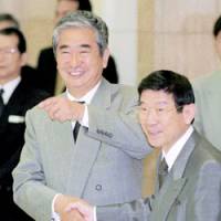 Former Tokyo Gov. Yukio Aoshima welcomes his gesturing successor, Shintaro Ishihara, at the Tokyo Metropolitan Government building in this photo taken in 1999. | KYODO PHOTO