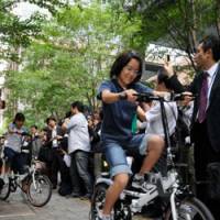 Pedal power: An elementary school girl tries out one of 50 public bikes that debuted in Tokyo\'s Marunouchi district on Thursday. | SATOKO KAWASAKI PHOTO