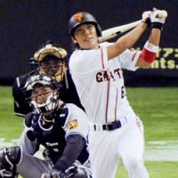 Yomiuri shortstop Hayato Sakamoto hits a grand slam in the fifth inning to help the Giants beat the Hanshin Tigers 9-1 on Sunday at Tokyo Dome. | KYODO PHOTO