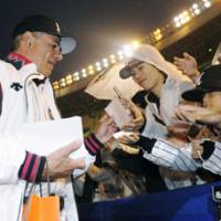 Hard to say goodbye: Chiba Lotte Marines manager Bobby Valentine gives thank you cards to fans before the Marines\' game against the Tohoku Rakuten Golden Eagles on Tuesday at Chiba Marine Stadium. Valentine managed the team to a 5-2 win in his final home game. | KYODO PHOTO