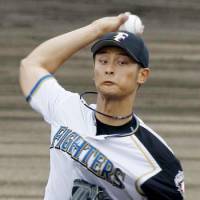 Solid start: Fighters right-hander Yu Darvish pitches against the Eagles in Nago, Okinawa Prefecture, on Saturday. He struck out three and allowed two runs in five innings in Nippon Ham\'s 7-2 win over Tohoku Rakuten. | KYODO PHOTO