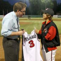 Special honor: Chico Outlaws pitcher Eri Yoshida gives National Baseball Hall of Fame official Brad Horn the jersey from her first game in the Golden Baseball League and the bat she used to record her first hit on May 30 during the seventh-inning stretch on Thursday in Chico, Calif. | AP PHOTO
