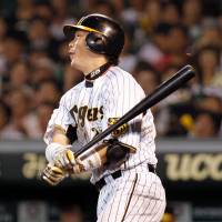 Just in time: Takahiro Arai hits an RBI single against the Giants in the sixth inning on Tuesday at Koshien Stadium. Hanshin won 2-1. | KYODO