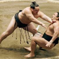 Down you go: Asashoryu dispatches Aminishiki on Day 8 of the New Year Grand Sumo Tournament at Ryogoku Kokugikan on Sunday. | KYODO PHOTO