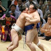 In control: Harumafuji eases Iwakiyama over the bales on the second day of the Nagoya Grand Sumo Tournament on Monday. | KYODO PHOTO