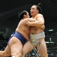 Big step back: Harumafuji (right) faces off against Kotoshogiku during the Nagoya Grand Sumo Tournament on Tuesday. The promotion-chasing Ozeki lost the bout. | KYODO PHOTO