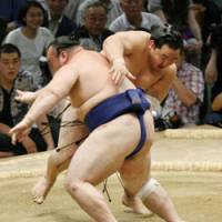 Forceful action: Yokozuna Asashoryu slaps Iwakiyama down on the seventh day of the Nagoya Grand Sumo Tournament on Saturday. | KYODO PHOTO