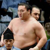 Leading the way: Hakuho walks in front of beaten opponent Kotooshu at the Nagoya Grand Sumo Tournament on Friday. | KYODO PHOTO