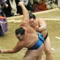 Rocket start: Yokozuna Asashoryu pushes Baruto out of the ring on the first day of the Autumn Grand Sumo Tournament in Tokyo on Sunday. | KYODO PHOTO