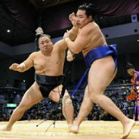Talk to the hand: Chiyotaikai thrusts a blow to the face of Kakuryu at the Kyushu Grand Sumo Tournament on Monday. | KYODO PHOTO