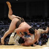 Sole leader: Yokozuna Hakuho (top) showcases his strength against Kotooshu on Friday in the Kyushu Grand Sumo Tournament. | KYODO PHOTO