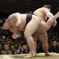 Going down: Asashoryu teeters over the edge of the ring before losing to Goeido at the New Year Grand Sumo Tournament on Thursday. | KYODO PHOTO