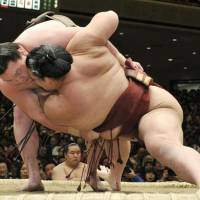Bouncing back: Hakuho (left) hauls down Kisenosato at the New Year Grand Sumo Tournament on Sunday. | KYODO PHOTO