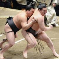 Upset special: Harumafuji pushes Hakuho out of the ring at the New Year Grand Sumo Tournament. | KYODO PHOTO