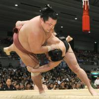 Show of strength: Ozeki Harumafuji (bottom) defeats Toyohibiki on Tuesday in the Spring Grand Sumo Tournament in Osaka. | KYODO PHOTO