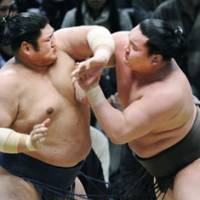 Close call: Yokozuna Hakuho (right) competes against Kotomitsuki during their bout on Thursday at the Spring Grand Sumo Tournament in Osaka. | KYODO PHOTO