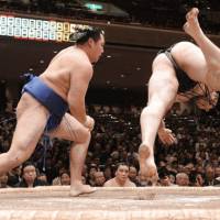 Ozeki Kotooshu is sent flying by Kakuryu on Friday, the sixth day of the Summer Grand Sumo Tournament in Tokyo. | KYODO PHOTO