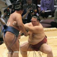 Getting the job done: Kisenosato (right) pushes Homasho out of the raised ring on Wednesday in the Kyushu Grand Sumo Tournament. | KYODO PHOTO