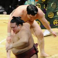 No problem: Hakuho (rear)  beats Kisenosato at the Kyushu Grand Sumo Tournament on Wednesday. | KYODO