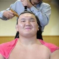 Taking it easy: Hakuho has his mage adjusted after his win at the Kyushu Grand Sumo Tournament | KYODO PHOTO