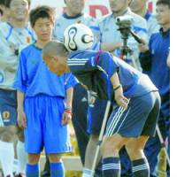 A boy watches as Japan midfielder Shinji Ono juggles the ball during the national team\'s training camp in Fukushima. | SATOKO KAWASAKI PHOTO