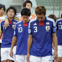 Members of the defeated Japan team walk off the playing field in Zibo, China, after losing their chance at a berth in the Under-20 World Cup. | KYODO PHOTO