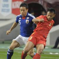 Competitive fire: Japan\'s Yuto Nagatomo (left) and a Vietnam player vie for the ball in first-half action on Friday in Kobe. Japan beat Vietnam 1-0. | KYODO