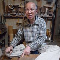 Master craftsman: Edo sashimono maker Yoshio Inoue points to a joint he has just cut with a hammer and chisel at his workshop in Tokyo. | MICHAEL KLEINDL