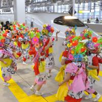 Finish line: Dancers from the famed Aomori Nebuta Festival welcome the first bullet train to arrive at Shin-Aomori Station in Aomori Prefecture, from Morioka, Iwate Prefecture, on Saturday morning. | KYODO PHOTO