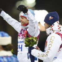 Norway\'s Ole Einar Bjoerndalen raises his arms after winning gold as Czech Republic\'s bronze winner Jaroslav Soukup looks on during the flower ceremony of the Men\'s Biathlon 10 km Sprint  at the Laura Cross- Country Ski and Biathlon Center during the Sochi Winter Olympics in Rosa Khutor.  | AFP-JIJI