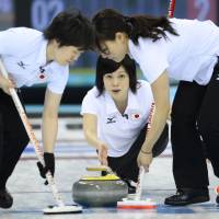 Brushed aside: Yumie Funayama (center) throws a stone during Japan\'s 8-4 defeat to Sweden in its final round-robin match at the Sochi Olympics on Monday. | AFP-JIJI