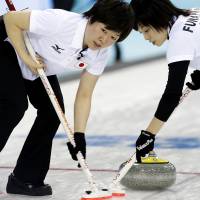 Working together: Michiko Tomabechi (left) and Yumie Funayama sweep the ice for Japan during a women\'s curling competition against South Korea on Tuesday in Sochi, Russia. | AP