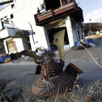 A rusting samurai warrior’s helmet rests on broken concrete in in Otsuchi, Iwate Prefecture, an area devastated by the 2011 earthquake and tsunami. | AP