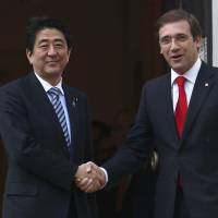 Prime Minister Shinzo Abe is welcomed by his Portuguese counterpart, Pedro Passos Coelho, in Lisbon on Friday. | REUTERS