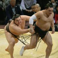 As expected: Hakuho forces fellow yokozuna Harumafuji out of the raised ring on Saturday at the Kyushu Grand Sumo Tournament. | KYODO