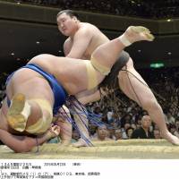 Back in front: Yokozuna Hakuho manhandles Kotoshogiku on Friday, the 13th day of the Summer Grand Sumo Tournament, at Ryogoku Kokugikan. | KYODO