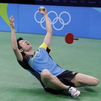 Japan\'s Jun Mizutani falls to the floor after defeating Vladimir Samsonov, of Belarus, to win the men\'s table tennis bronze medal match at the 2016 Summer Olympics in Rio de Janeiro on Thursday. | AP