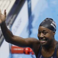 United States\' Simone Manuel waves after winning the gold and setting a new Olympic record in the women\'s 100-meter freestyle during the swimming competitions at the 2016 Summer Olympics on Thursday. | AP