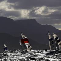 Sailors compete under the Christ the Redeemer statue during Thursday\'s preliminary round for the men\'s two-person dinghy at the Rio de Janeiro Olympics. | REUTERS