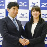 Japan national team swimming coach Norimasa Hirai (left) and two-time Olympic bronze medalist Natsumi Hoshi attend a news conference on Tuesday, when Hoshi formally announced her retirement. | KYODO