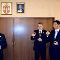 President of the Japan-Serbia Society and former Ambassador to Serbia Tadashi Nagai (left) raises his glass along with State Minister for Foreign Affairs Nobuo Kishi (right) and Serbia\'s Ambassador Nenad Glisic at a Serbian national day reception at the embassy on Feb. 15. | SERBIA EMBASSY