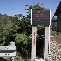 A sign in Chinese and Korean warns against harboring or feeding North Koreans who cross into a village near Linjiang in northeastern China's Jilin province i August. | AP